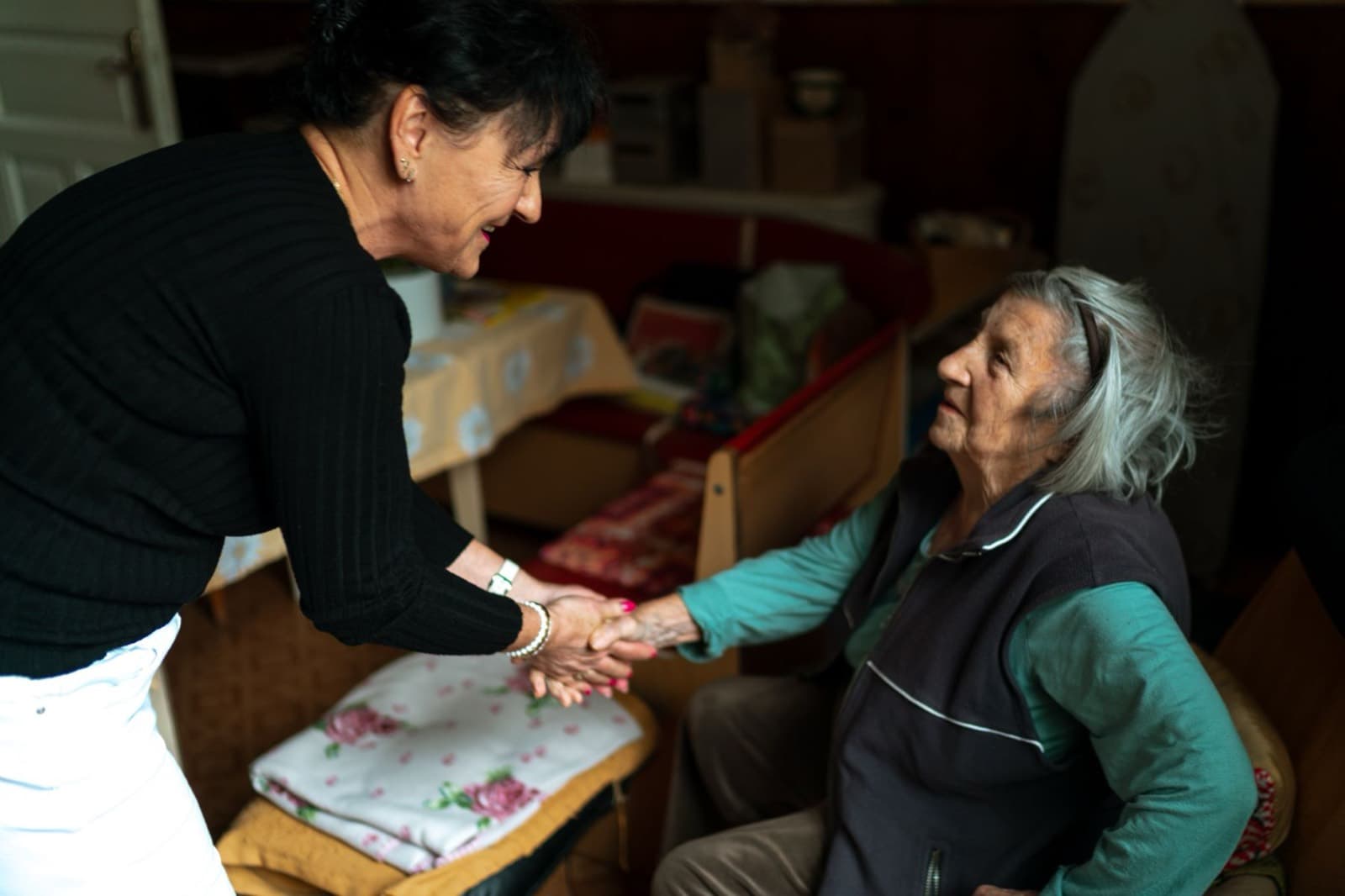 A carer warmly greeting an older person at home